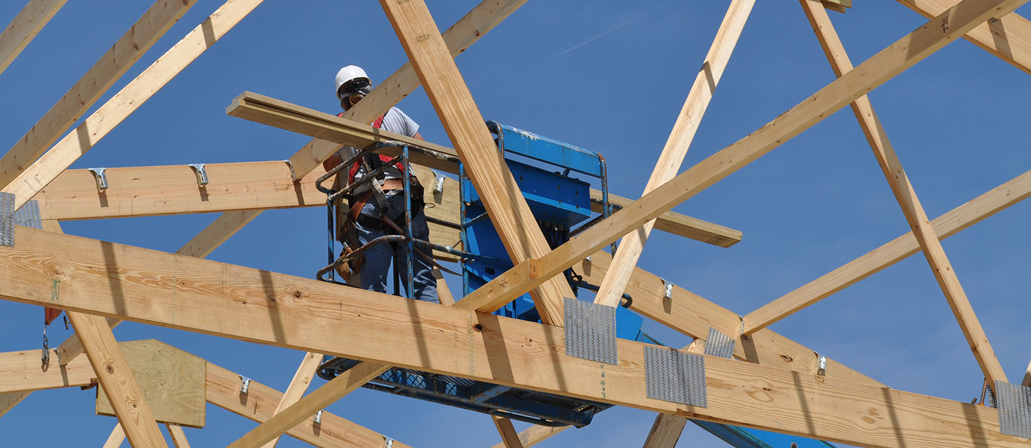 Male employee working on post frame roof construction